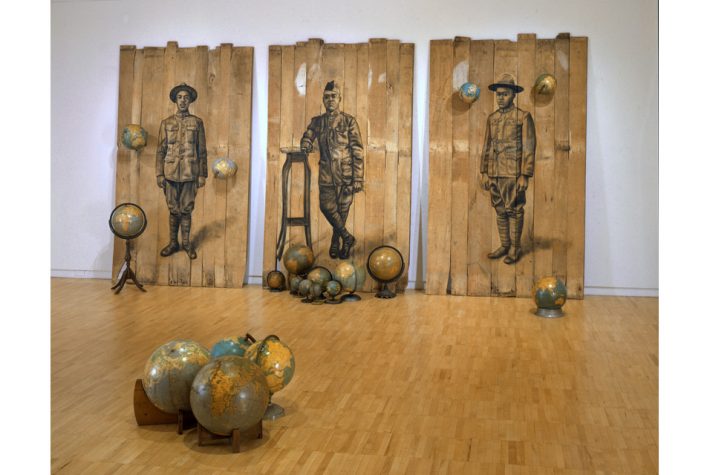 Whitfield Lovell (b. 1959), Autour du Monde, 2008. Conte crayon on wood panels with globes 102 x 189 x 171 inches, Courtesy of the artist and DC Moore Gallery, New York.