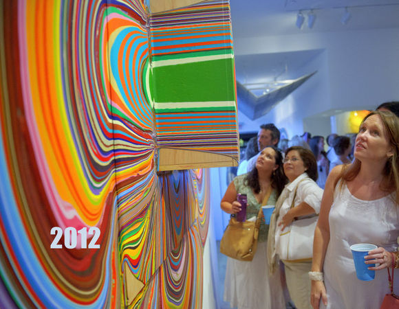 MATTHEW HINTON / THE TIMES-PICAYUNE Stephanie Dovalina, center, background, her mother Monica Dovalina, and friend Kristen Nygren, foreground right, look at the work of Holton Rower called "Love Heals" at the Arthur Roger gallery on Julia Street during White Linen Night in New Orleans, La., Saturday, Aug. 4, 2012. The painting technique involves pouring successive quantities of modified paint onto plywood. The paint, sometimes mixed with reflective or opalescent elements, flows slowly and determinedly over the surfaces resulting in amorphous shapes. The works vary from an inch thick to including protrusions called "hats" that extend out by a foot. Other paintings feature "exclusions", points where the artist placed obstacles that were later removed, forcing the paint to change direction.