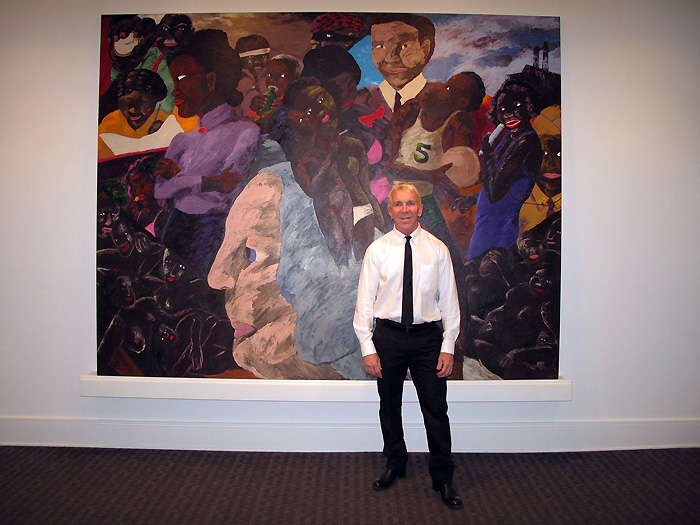 New Orleans gallerist Arthur Roger with a Robert Colescott painting at his gallery