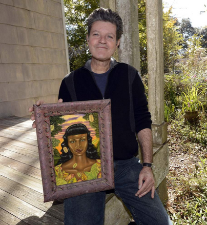 Advocate Staff Photo by Bill Feig - Douglas Bourgeois holds a 2001 painting of his, 'Woman with Lady Beetles' on his front porch. Bourgeois, a painter who lives in St. Amant, LA, near Gonzales, is a Prospect.3 artist.